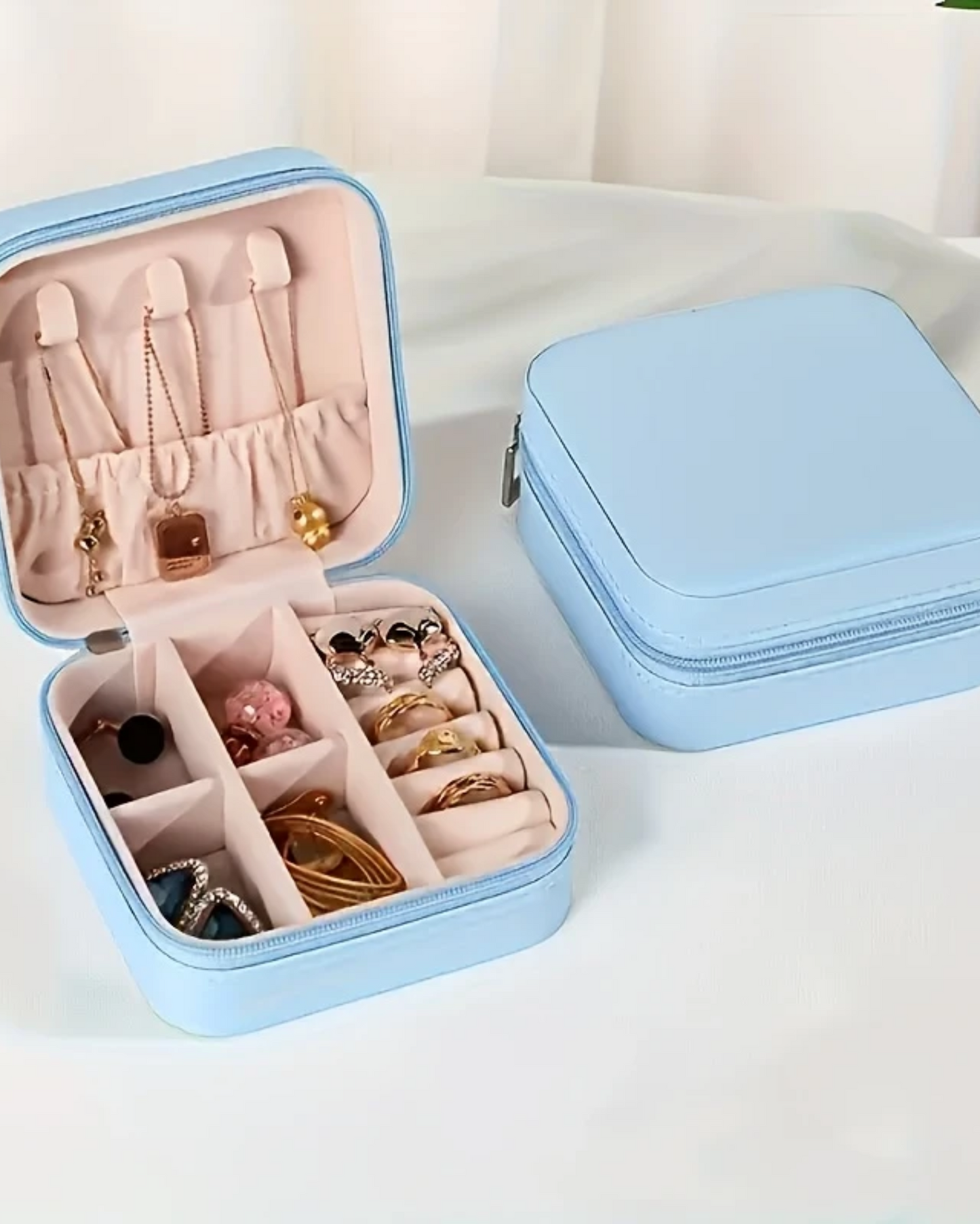 Light blue jewelry box with jewelry inside on a white background