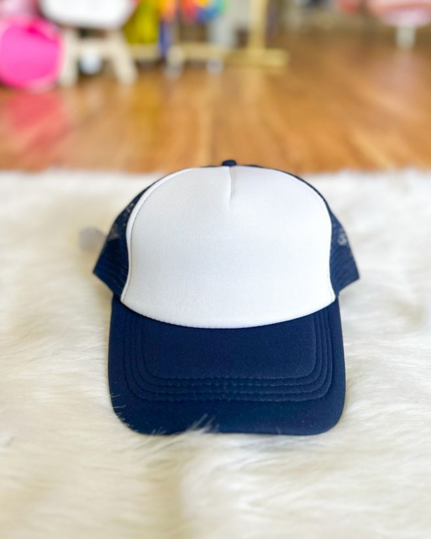 Navy and white cap on a fluffy white surface with a blurred background
