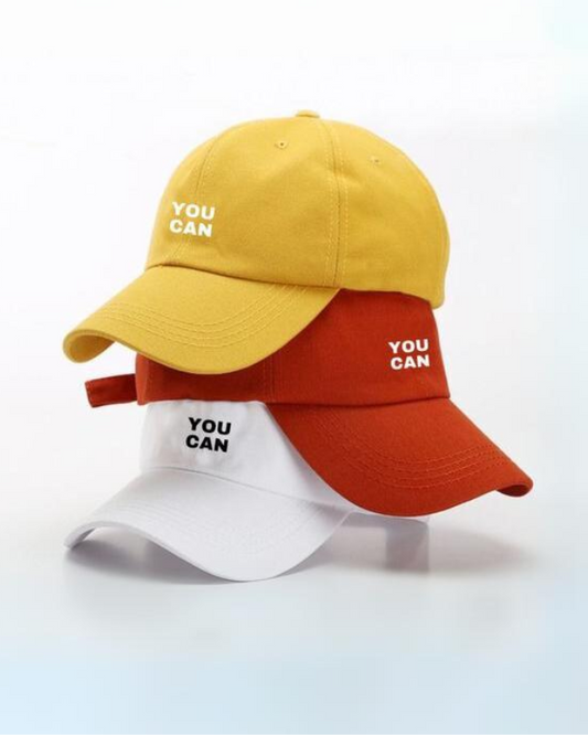 A collection of three blank caps in yellow, white, and red, with the text 'you can' printed on the front.